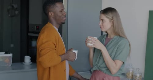 Couple Talking and Drinking in Kitchen