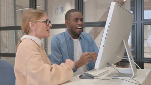 Excited Man and Woman Celebrate Success at Computer