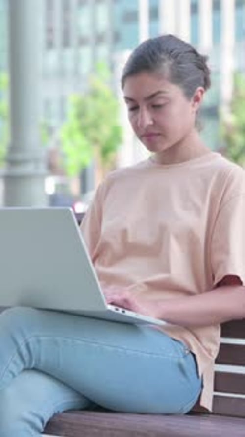 Indian Woman Looking at Camera while using Laptop in Office, Vertical Video