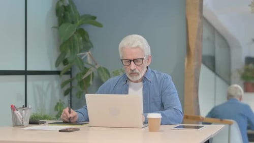 Senior Man Working on Computer with Drawing Tablet