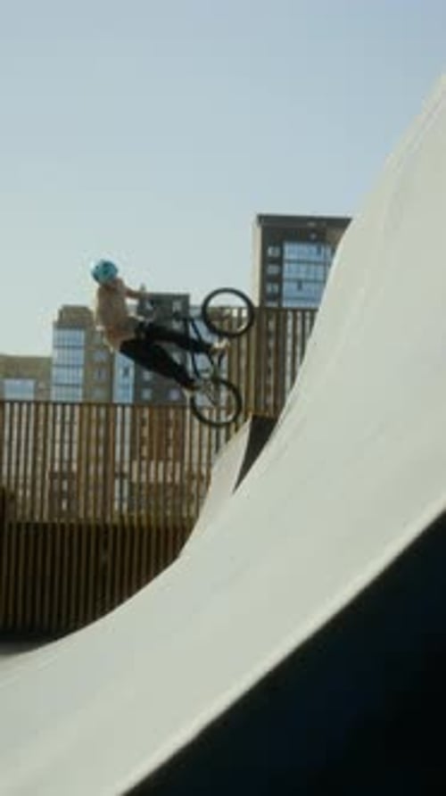 BMX Rider Riding Up Ramp and Performing Air Trick