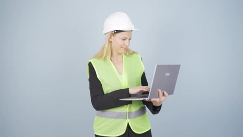 Ingenieur hält Laptop in der Hand und lacht in die Kamera.