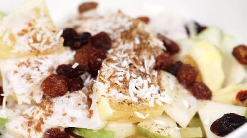 Bowl of Delicious Fruit Salad with Coconut and Raisins