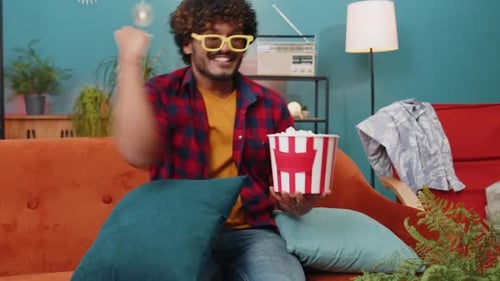 Man Laughing, Watching Movie with Popcorn at Home