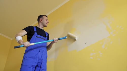 Man doing new room interior with paint. Young handsome male doing renovation.