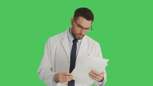 Mid Shot of a Serious-Minded Scientist Working With Papers. Background Is Green Screen.