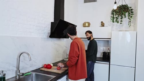 Man Cuts Vegetables in Modern White Kitchen