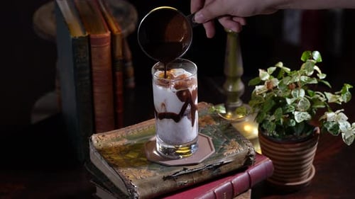 Dieses Video zeigt, wie man einen Schokoladen-Latte zubereitet, indem man Schokoladensauce in Milch gießt