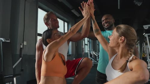 Athletic Group Celebrates with High Five at Gym