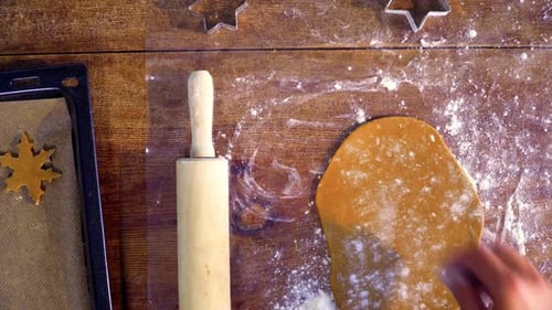 Woman Rolling Dough to Bake Holiday Cookies