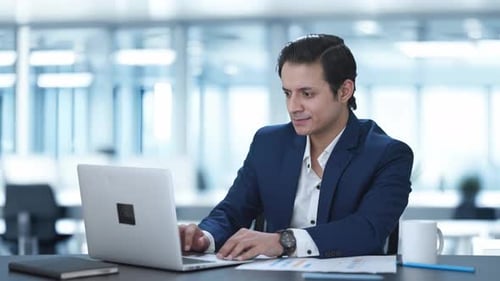Happy Indian corporate employee working on laptop