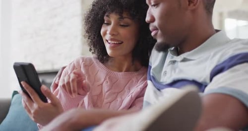 Cheerful Couple Relaxing and Using a Mobile Phone