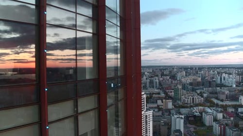 Aerial View of a Modern Glassed Office Skyscraper Exterior with Cityscape Reflection in the Windows