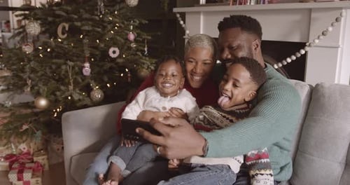 Happy Family Takes Holiday Selfie by Christmas Tree