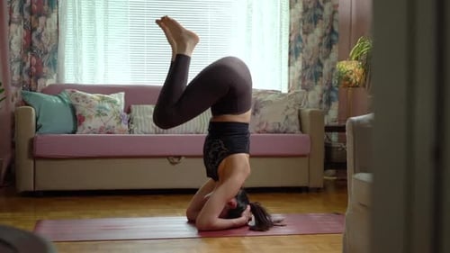Woman Doing Headstand Yoga Pose at Home