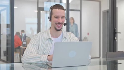 African American Man Looking at Camera while Working on Laptop in Office