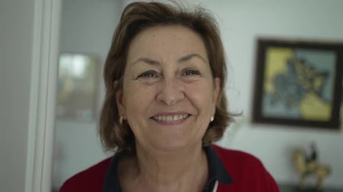Close-Up of Elegant Elderly Woman with Light Hair and Eyes, Wearing Earrings and Red Blouse,