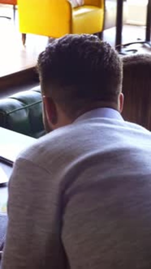 Une femme aux cheveux roux bouclés est engagée dans une conversation à l'extérieur avec un arrière-plan flou urbain