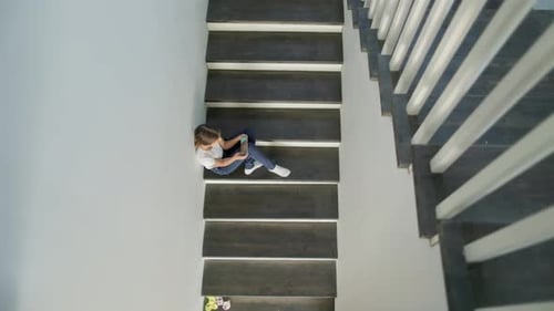Child Sits on Stairs Using Tablet Device