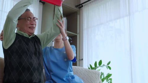 Senior Man Exercising with Resistance Band and Therapist