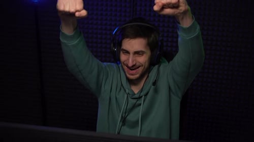 Excited Gamer Celebrates Victory in Dark Room