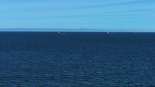 Seascape with Several Cargo Ships Floating on Calm Ocean Surface Maritime View Showing Bulk Carriers