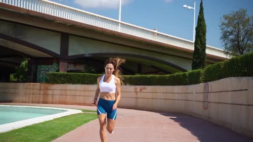 Woman Jogging Towards Camera in Urban Park