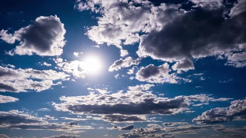 Timelapse of Cumulus Clouds Moving In The Blue Sky Against The Sun