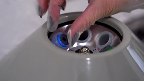 Gloved Hand Using Laboratory Centrifuge