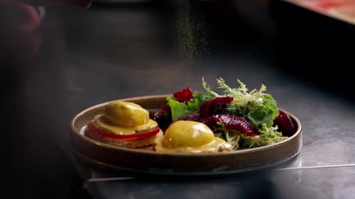 Close Up in a Professional Kitchen on Clean Metal Table a Woman Chef Collects a Salad with Fresh