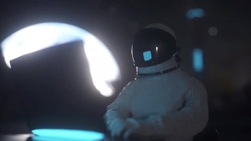 Astronaut Working on Laptop in Space Station