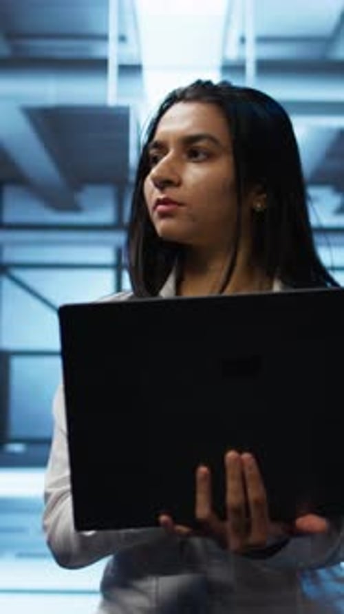 Woman Holding a Laptop in Data Server Room