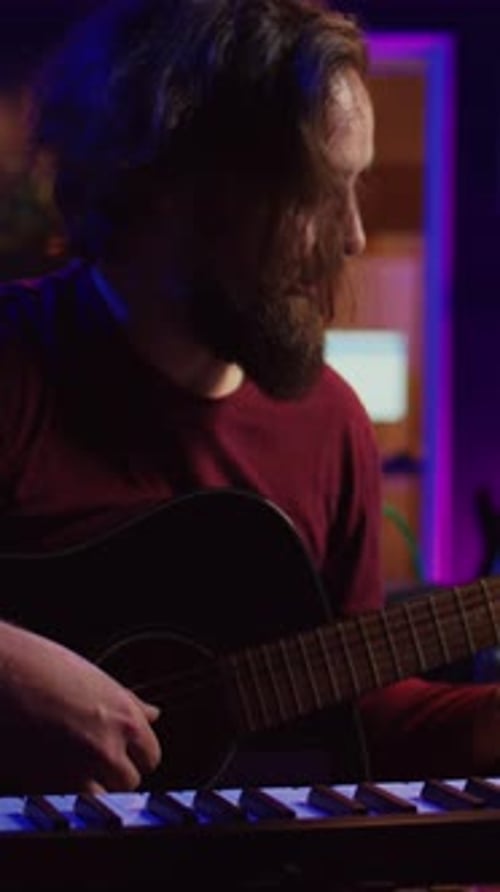 Vertical Video Artist Composing a Song with His Acoustic Guitar in Home Studio