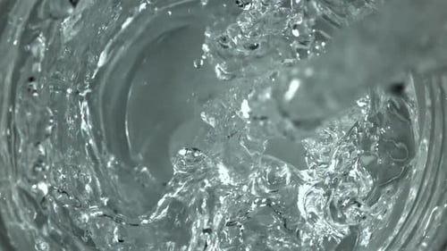 Se vierte agua en un vaso filmado con una cámara de alta velocidad a 1000 fps