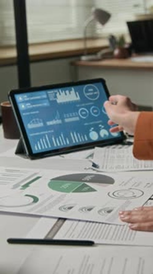 Colleagues Analyzing Digital Charts and Paper Documents