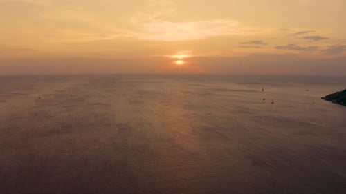 Orange sunset over the sea. The sun is setting over the horizon. Evening view of the mountains and s