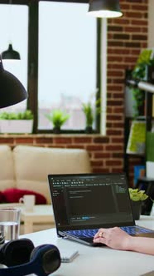 Woman Working on Laptop in Urban Apartment