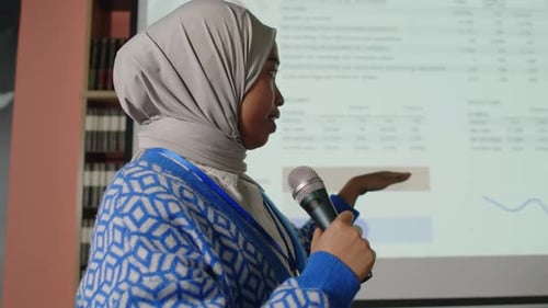 Muslim Female Speaker in Hijab Explaining Presentation to Audience on Seminar