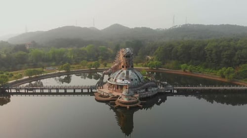 Aerial view of abandoned waterpark by lake at sunrise, Vietnam.