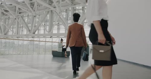 Dolly Shot of Business Lady Walking in Airport Terminal Meeting Partner While People in Suits Moving
