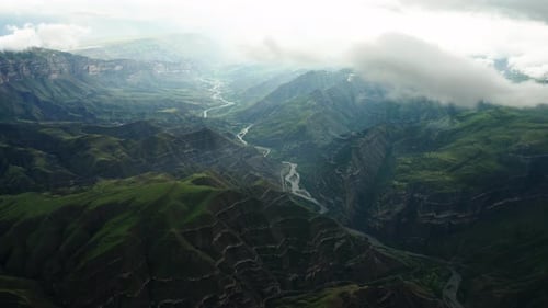 Sunlit River Winding Through Mountains Sunlight Breaks Through Clouds Illuminating a River Winding