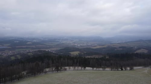 A flight over the countryside with a path leading through the trees and a view of the surrounding th