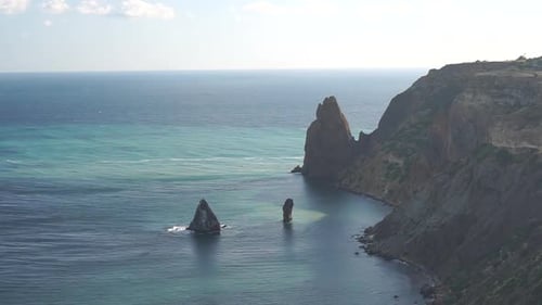 Aerial View on Azure Sea and Volcanic Rocky Shores Fluffy Cumulus Clouds Moving in Bright Sunset Sky