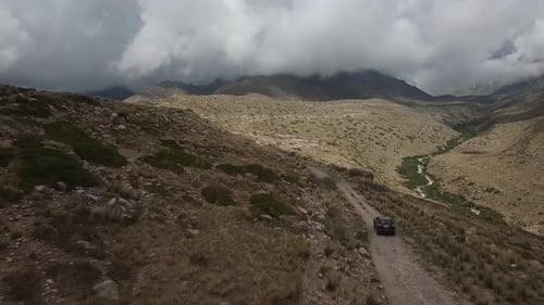 Drone: flies behind a car through a gorge in the mountains of Kyrgyzstan