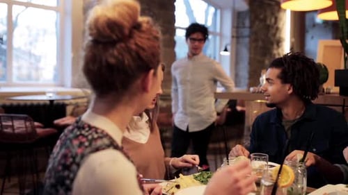 Group of Friends Eating and Socializing at Restaurant