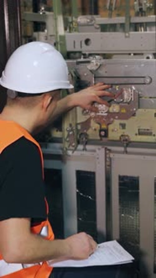 A Male Utility Worker Checks the Operation of an Elevator in a Residential Building There is a
