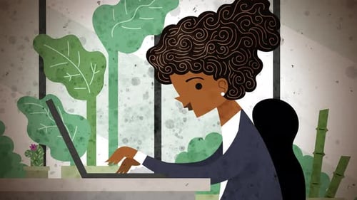 happy office employee working at a computer in a plant filled office