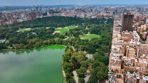 Marvelous scenery of Central Park with lake. Sunny cityscape of New York from aerial perspective.