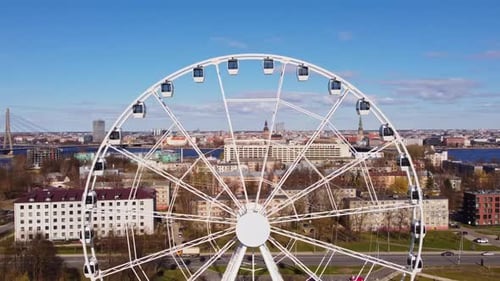 Giant Ferris Wheel Overlooking River and Panoramic City Skyline View