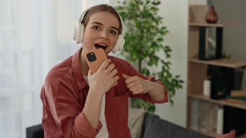 Young Woman Singing with Headphones and Phone